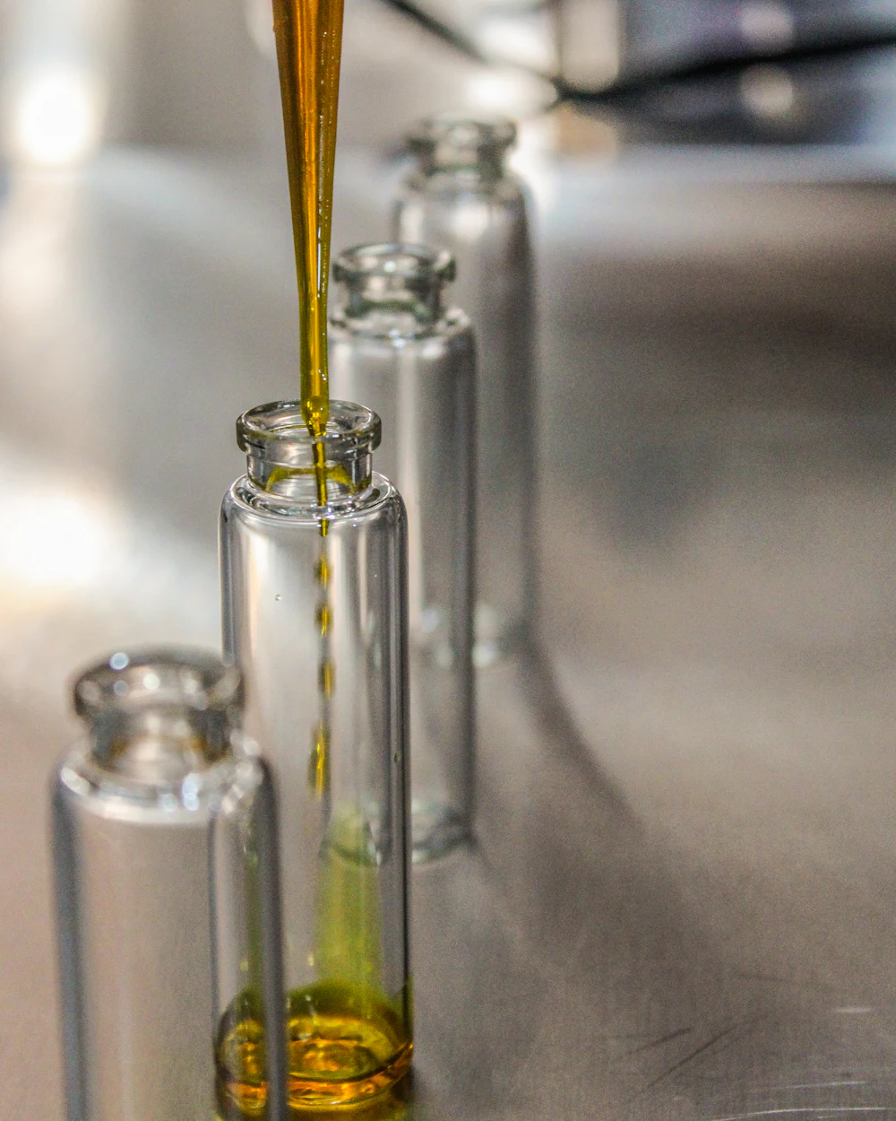 Olive oil being pipetted into laboratory vials for analysis